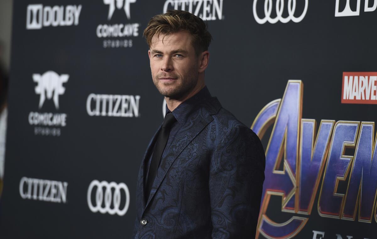 Chris Hemsworth in a dark suit, dark shirt and dark tie
