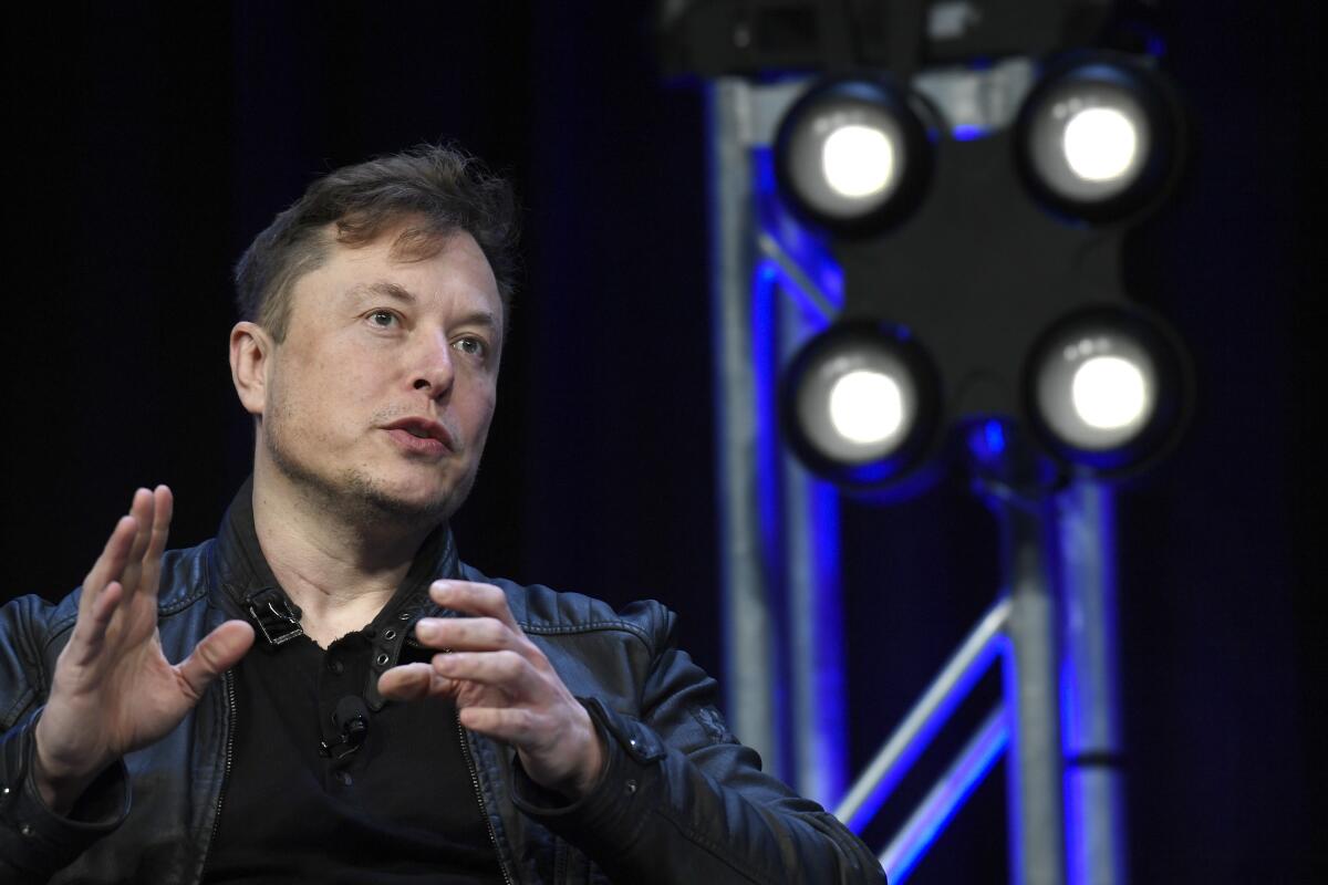 A man gestures as he speaks onstage.