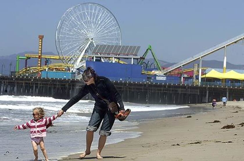 Anne Metge-Ollier of Aubenas, France, plays with her daughter, Carla, 3, near the Santa Monica Pier. Water quality around the pier was found to be among the worst in the state in a survey by the environmental watchdog group Heal the Bay.