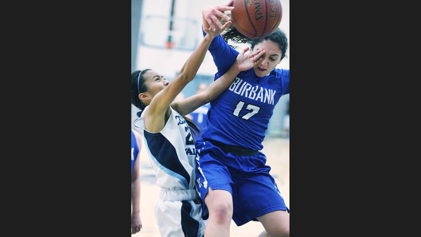Crescenta Valley's Denise Dayag drives for a layup just as Burbank's Ani Sarkisyan crashes through for a block and foul in a Pacific League girls' basketball game at Crescenta Valley High School on Tuesday, January 3, 2017.