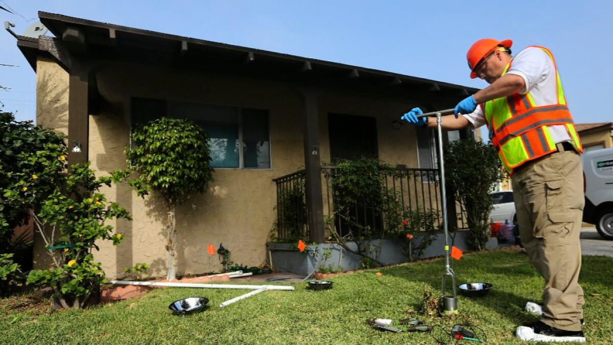 An L.A. County environmental health specialist collects a soil sample in Commerce.
