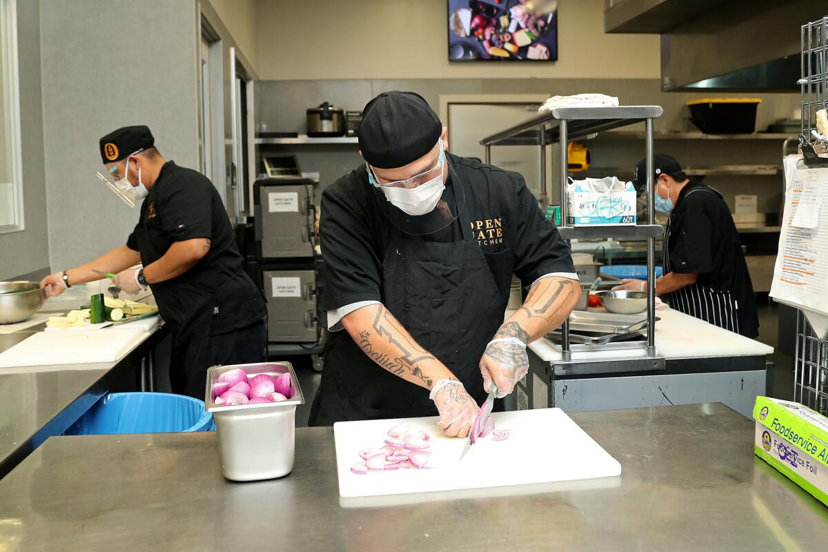 Prep cook Michael Rodriguez, 25, of Stanton slices red onions at Open Gate Kitchen in Costa Mesa. 