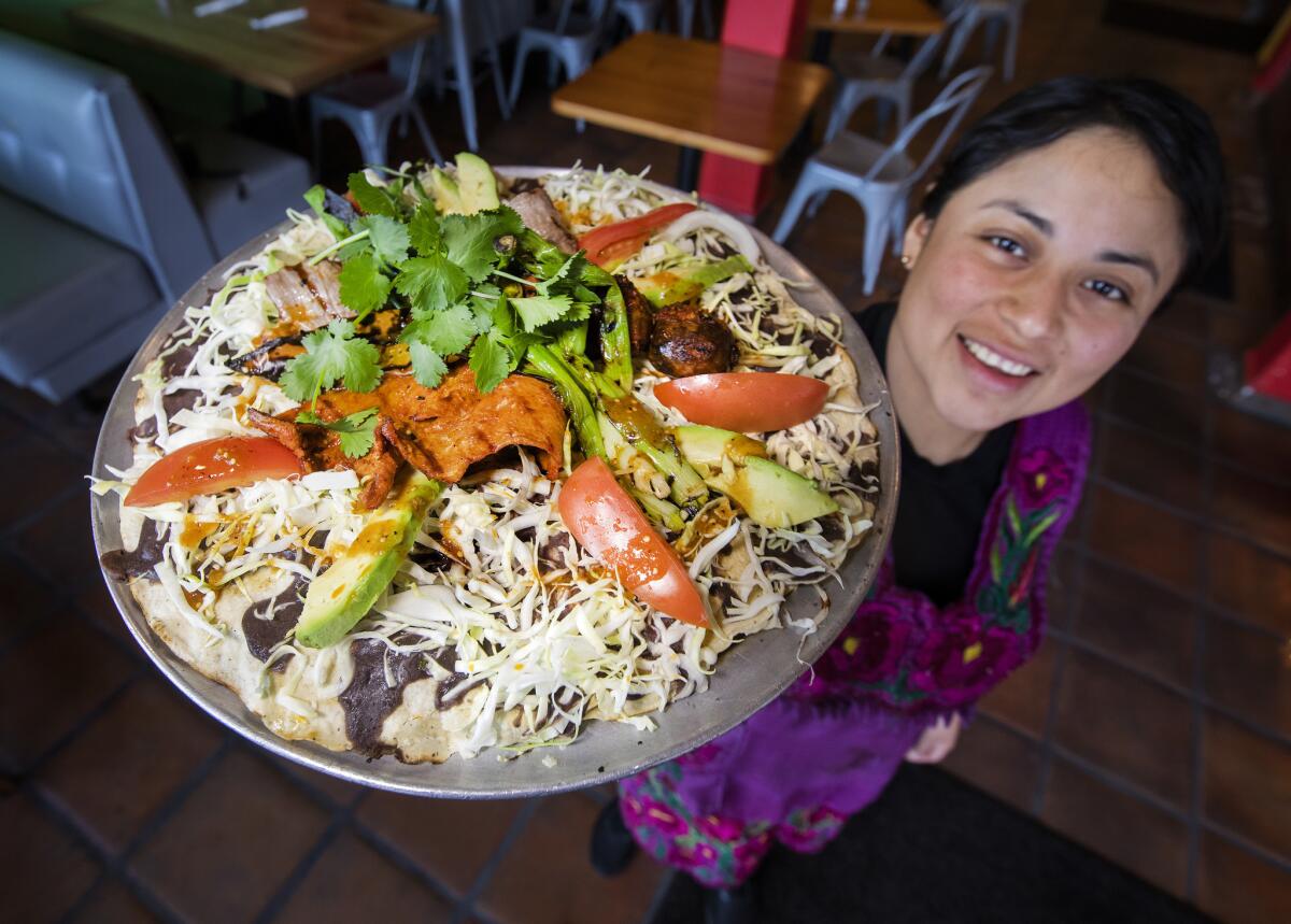 Melissa Martinez, co-owner of Quiadaiyn, with the Oaxacan restaurant's tlayuda mixta.