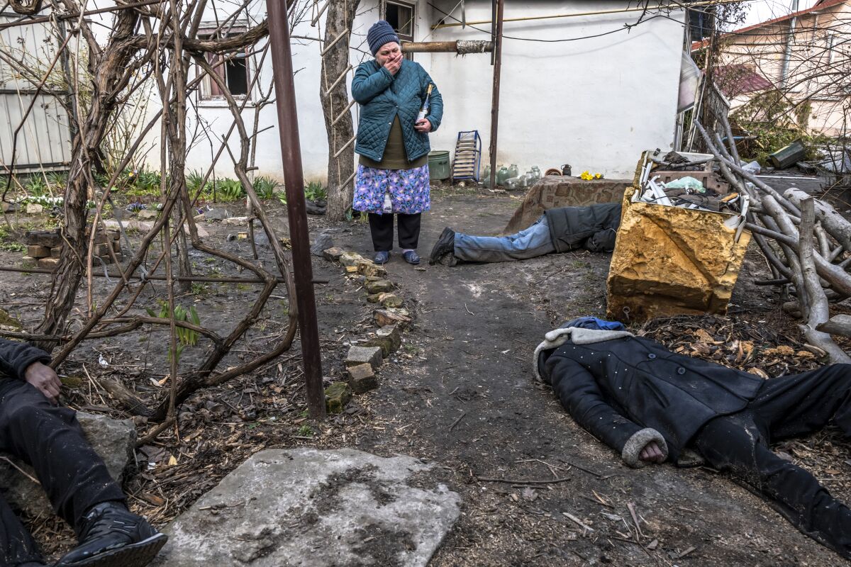 A woman reacts as she views the bodies of three civilians in a yard in Bucha, a suburb of Kyiv, Ukraine.