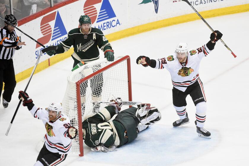 Brad Richards (91) and Bryan Bickell (29) of the Blackhawks celebrate a goal as Ryan Suter (20) and Devyn Dubynk (40) of the Wild look on during the third period in Game Four of the Western Conference Semifinals.