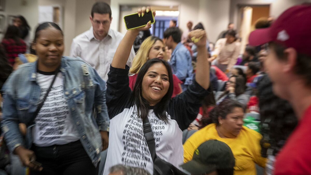 Audience members celebrate after the LAUSD school board voted June 18 to end their controversial policy of interrupting classes to randomly search students with metal detector wands,