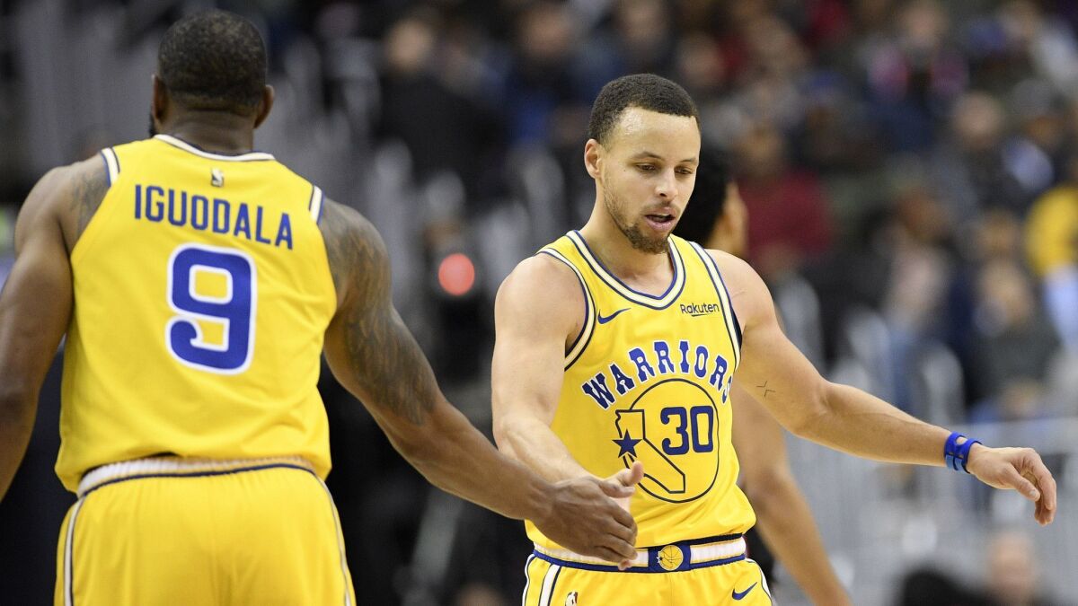 Golden State Warriors guard Stephen Curry (30) and guard Andre Iguodala (9) react during the second half of the team's NBA basketball game against the Washington Wizards.