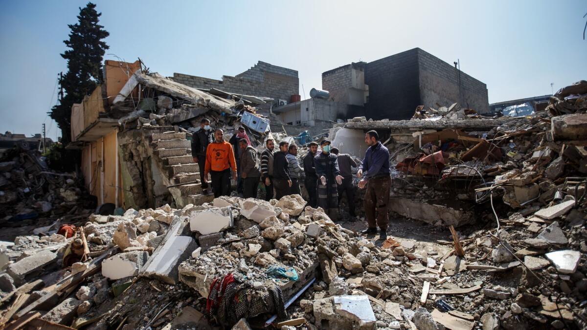 Residents work with their hands on March 24 to remove bodies from the rubble of a home destroyed in an apparent airstrike in Mosul, Iraq.