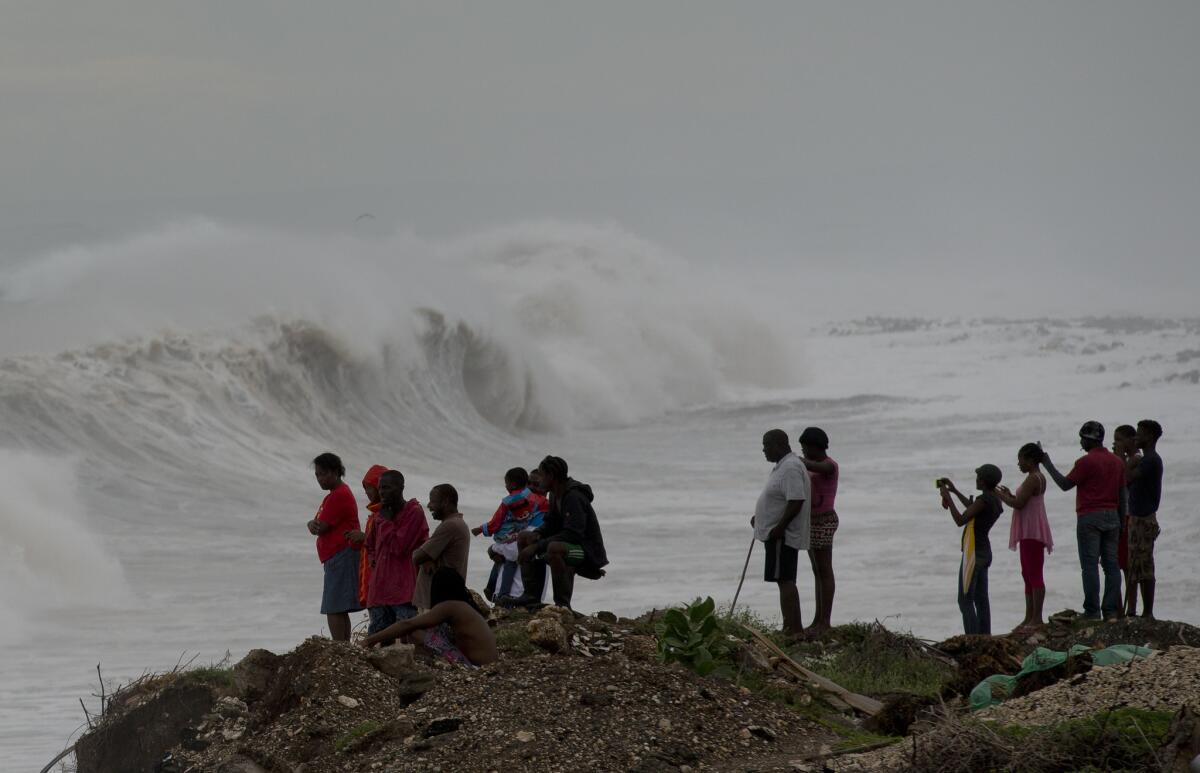 People in Jamaica watch surf generated by Hurricane Matthew on the outskirts of Kingston.