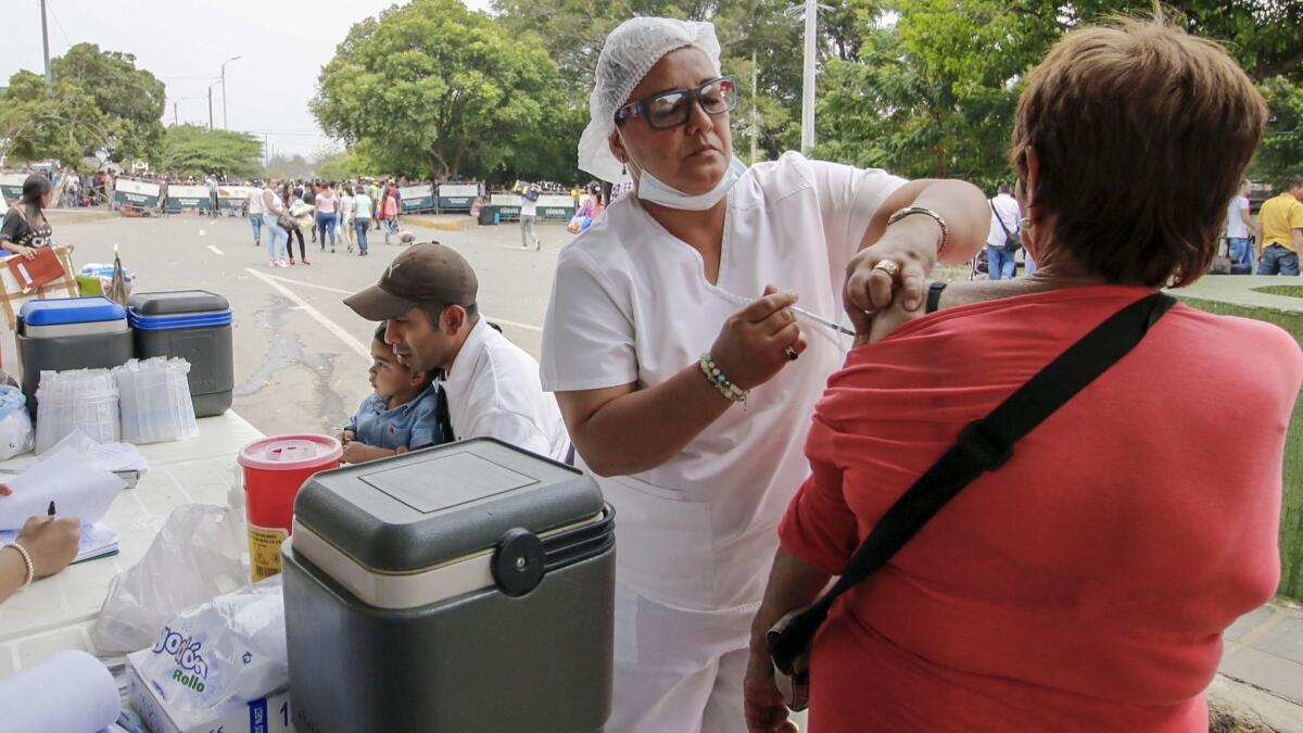 A Venezuelan woman is vaccinated against measles in Cucuta, Colombia, at the Simon Bolivar International Bridge on the border with Venezuela.