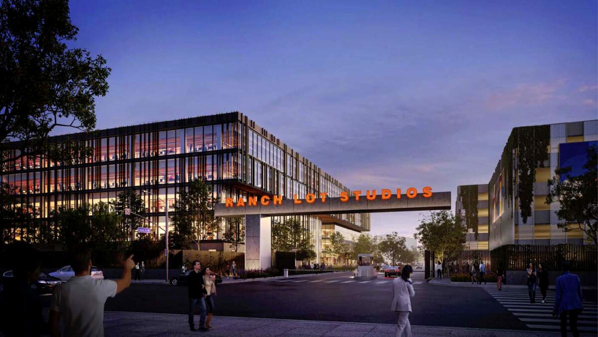 A large building with walls of glass and a neon sign that reads Ranch Lot Studios.