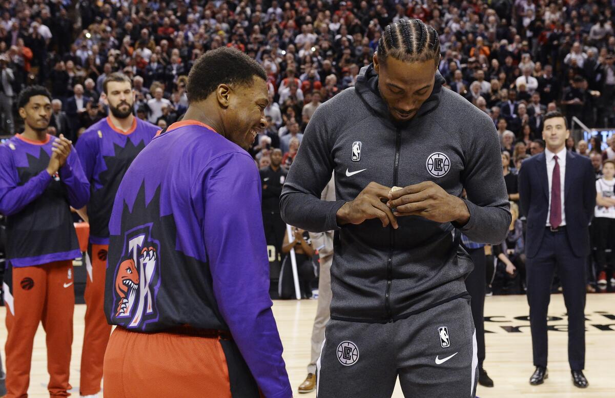 Clippers forward Kawhi Leonard is present with high 2019 NBA championship ring by former teammate Kyle Lowry before the game against the Raptors on Dec. 11, 2019, in Toronto.