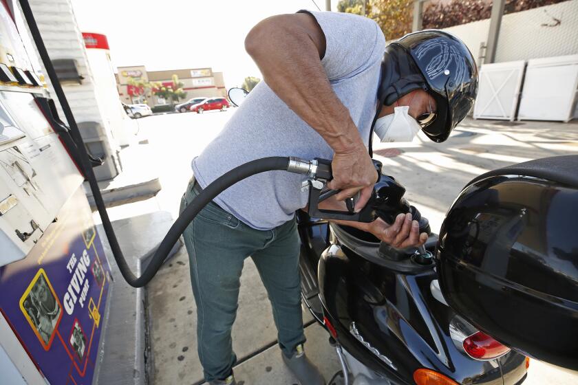 LOS ANGELES, CA - NOVEMBER 15: Mario Anaya, 63, fills his Vespa with one and a half gallons and is now making trips on two wheels instead of four to save on fuel cost as drivers select from various fuels priced near of above over $6 dollars at a Shell gas station located at South Fairfax, West Olympic and San Vicente Blvd in Los Angeles as California gas prices hit an average price of $4.676 Sunday, setting the highest recorded average price for regular gasoline, according to AAA. America's largest state by population has the highest gas prices in the country. The national average dropped slightly to $3.413 Sunday. Carthay Circle on Monday, Nov. 15, 2021 in Los Angeles, CA. (Al Seib / Los Angeles Times).