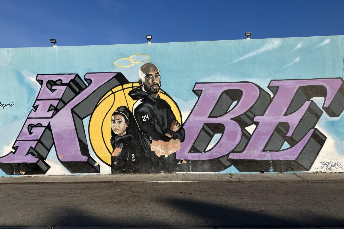 A mural shows Kobe Bryant and daughter Gianna standing with their backs to each and with Kobe's first name in huge letters