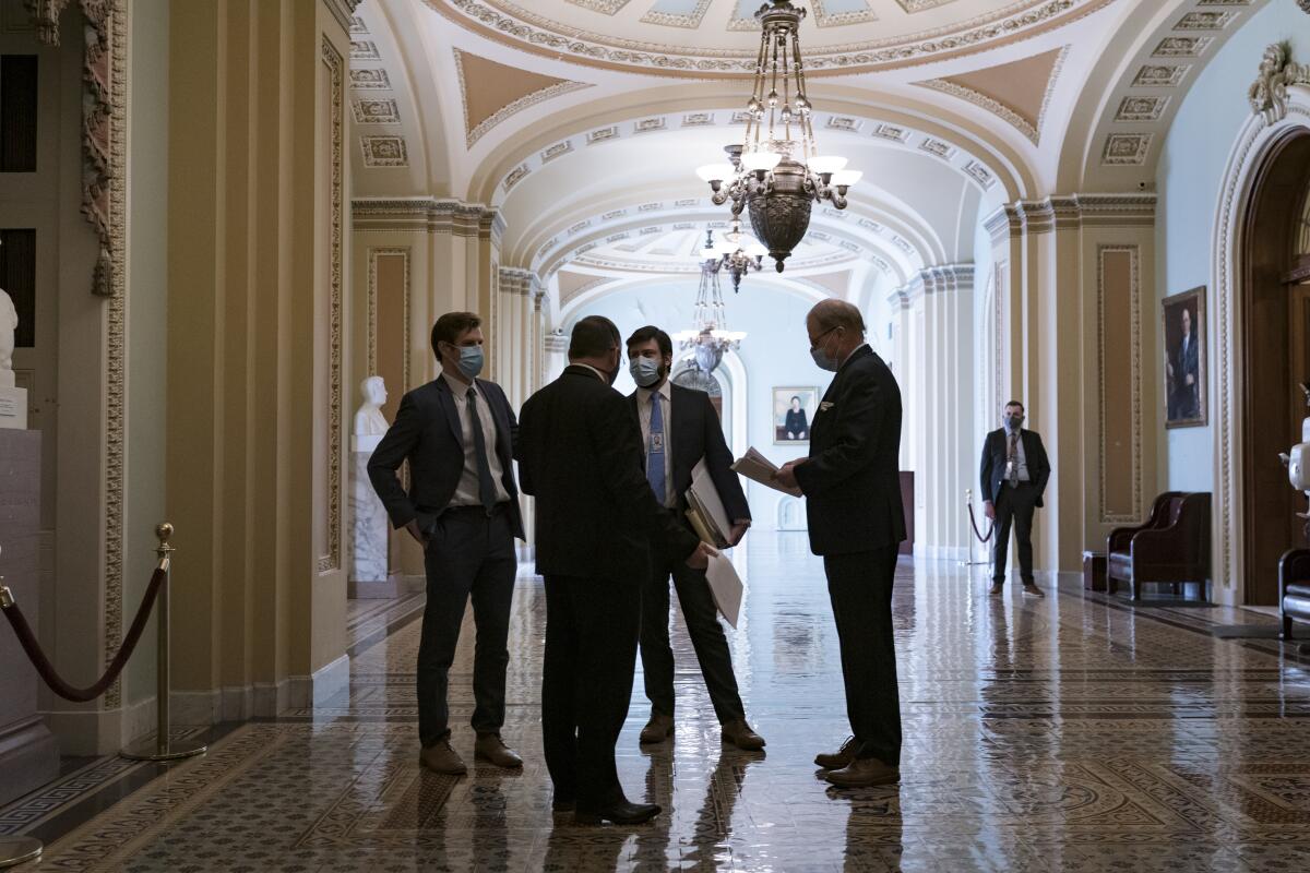 Personal del Congreso espera en un ornamentado pasillo en el exterior de la cámara del Senado 