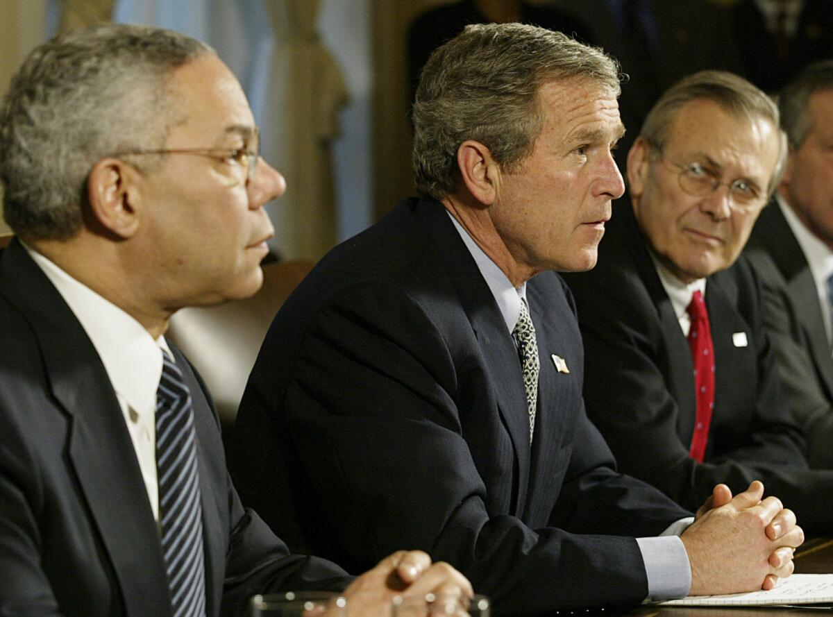 Then-Secretary of State Colin Powell attends a Cabinet meeting at the White House with President George W. Bush and then-Secretary of Defense Donald Rumsfeld on March 20, 2003.
