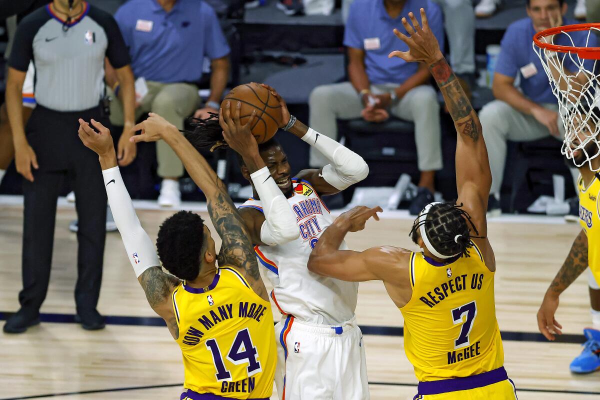 Oklahoma City Thunder's Nerlens Noel is defended by Lakers' Danny Green and JaVale McGee during the second quarter.