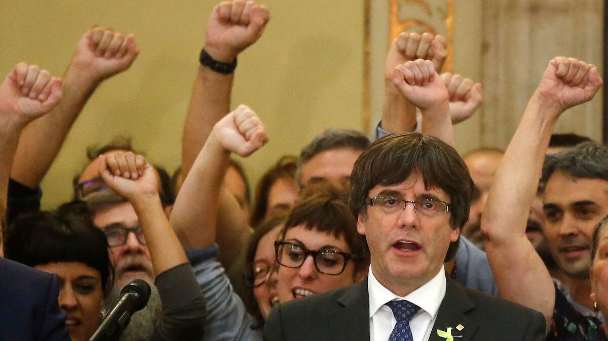 Catalan President Carles Puigdemont sings the Catalan anthem on Friday inside the parliament in Barcelona after a vote on independence. Soon after, the Spanish government ousted him and dissolved parliament.