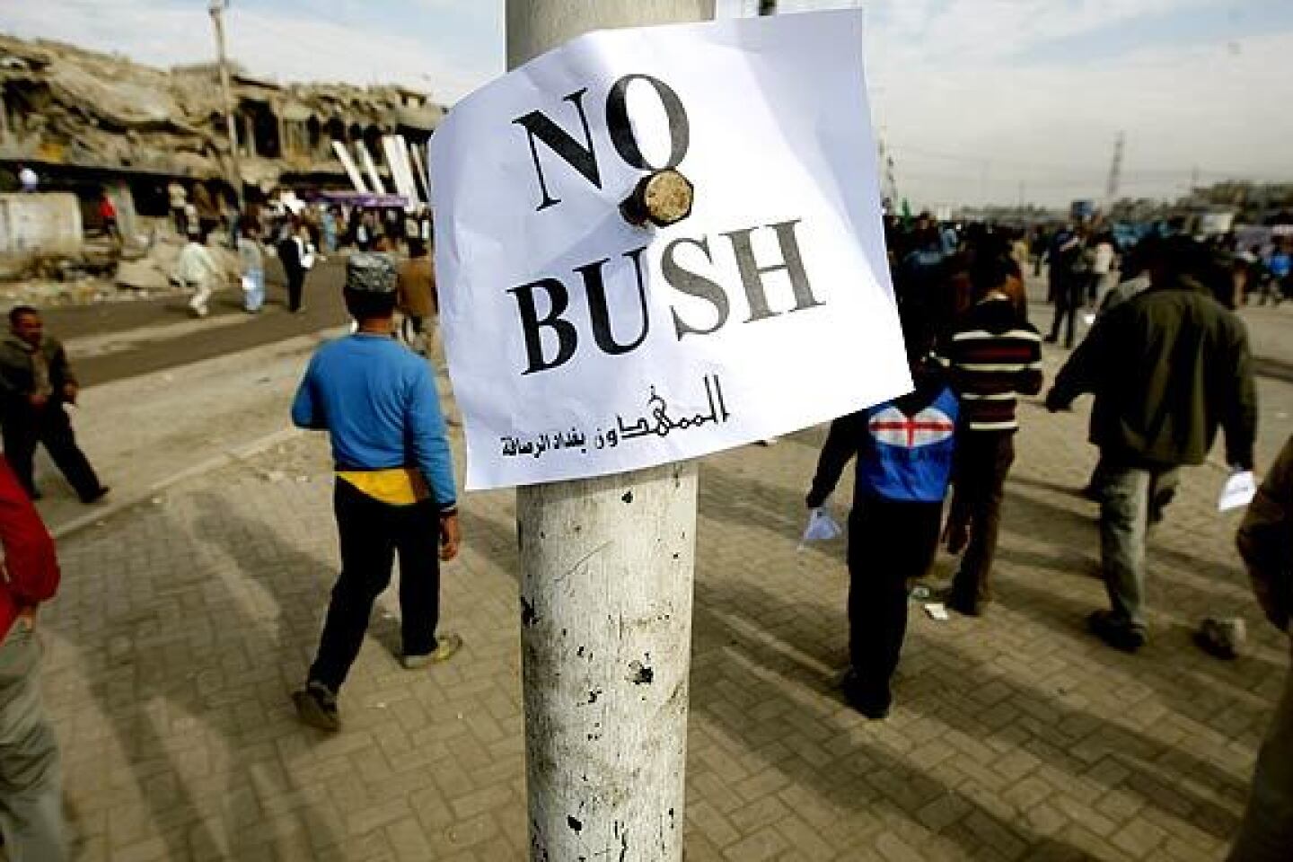 A protest sign is placed on a pole in Sadr City after the arrest of an Iraqi journalist who threw his shoes at President Bush during the president's surprise farewell visit to Iraq.