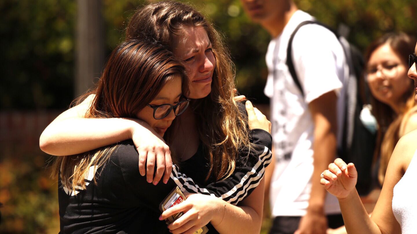 UCLA student Mai Que Vo, left, comforts India McFarlane, who was crying as students wrote notes to be placed on the Bruin Walk bear Thursday, a day after the deadly shooting of an engineering professor on campus.