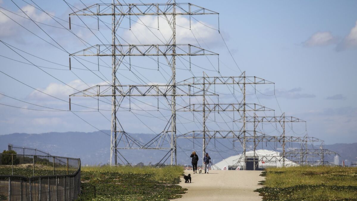 People walk along an area known locally as "The Dunes" on the western edge of El Segundo.
