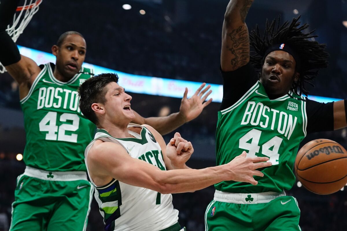 Milwaukee Bucks' Grayson Allen passes around Boston Celtics' Robert Williams III and Al Horford during the first half of Game 3 of an NBA basketball Eastern Conference semifinals playoff series Saturday, May 7, 2022, in Milwaukee. (AP Photo/Morry Gash)