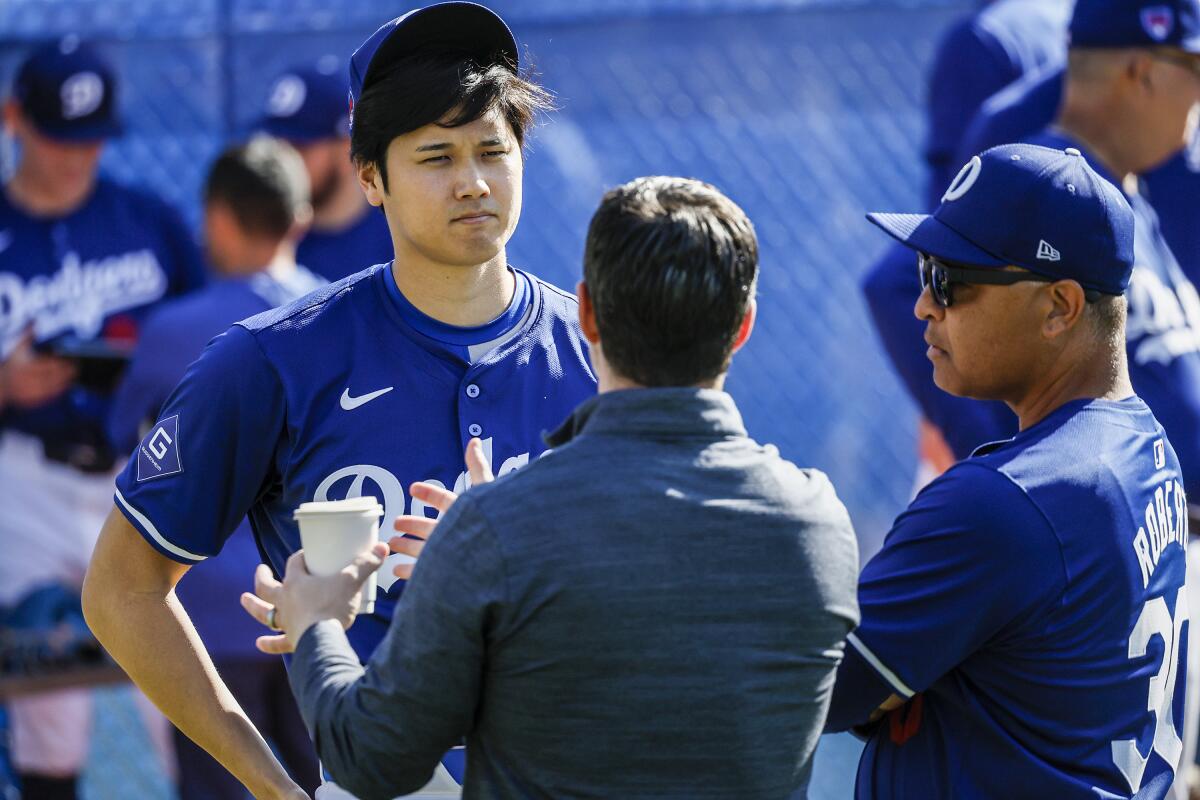 Dodgers star Shohei Ohtani talks with Dodgers president of baseball operations Andrew Friedman and manager Dave Roberts.
