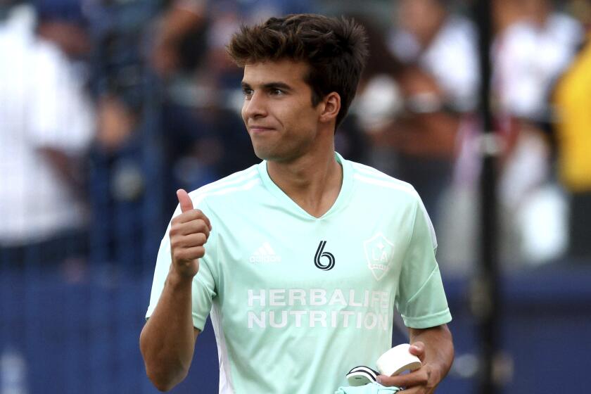 LA Galaxy midfielder Riqui Puig gestures to fans before an MLS soccer match.