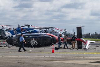 Officials inspect a crashed helicopter at Sacramento Executive Airport on Wednesday, 