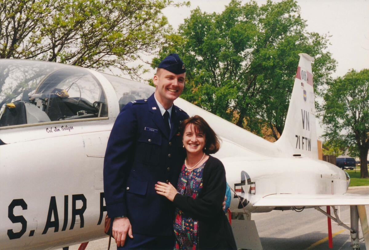 Johnson and wife Jill Koshak-Johnson pose in front of a T-38 aircraft.