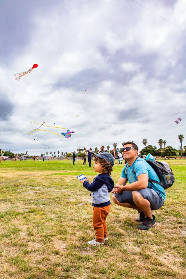 Rian Murphy and his father, John, keep their eyes on the sky at the OB Kite Festival on May 21 at Robb Field.