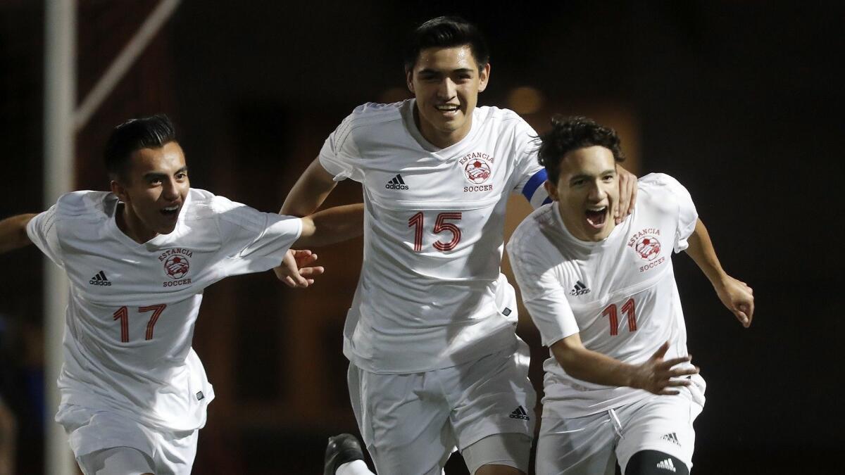 Sergio Gutierrez (15) celebrates with Andreas Millan (17) and Nico Ramirez (11) after the Eagles take a 2-1 lead against Dana Hills in a CIF Southern Section Division 3 first-round playoff match on Feb. 16.