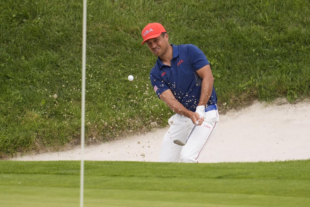 Xander Schauffele of the United States chips out of a bunker.