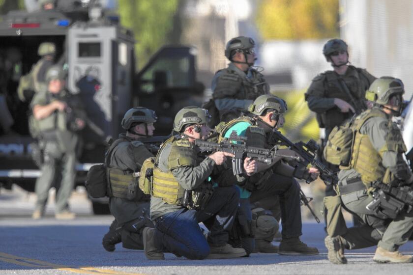 SWAT officers crouch on Richardson Street as they search for the San Bernardino shooters.