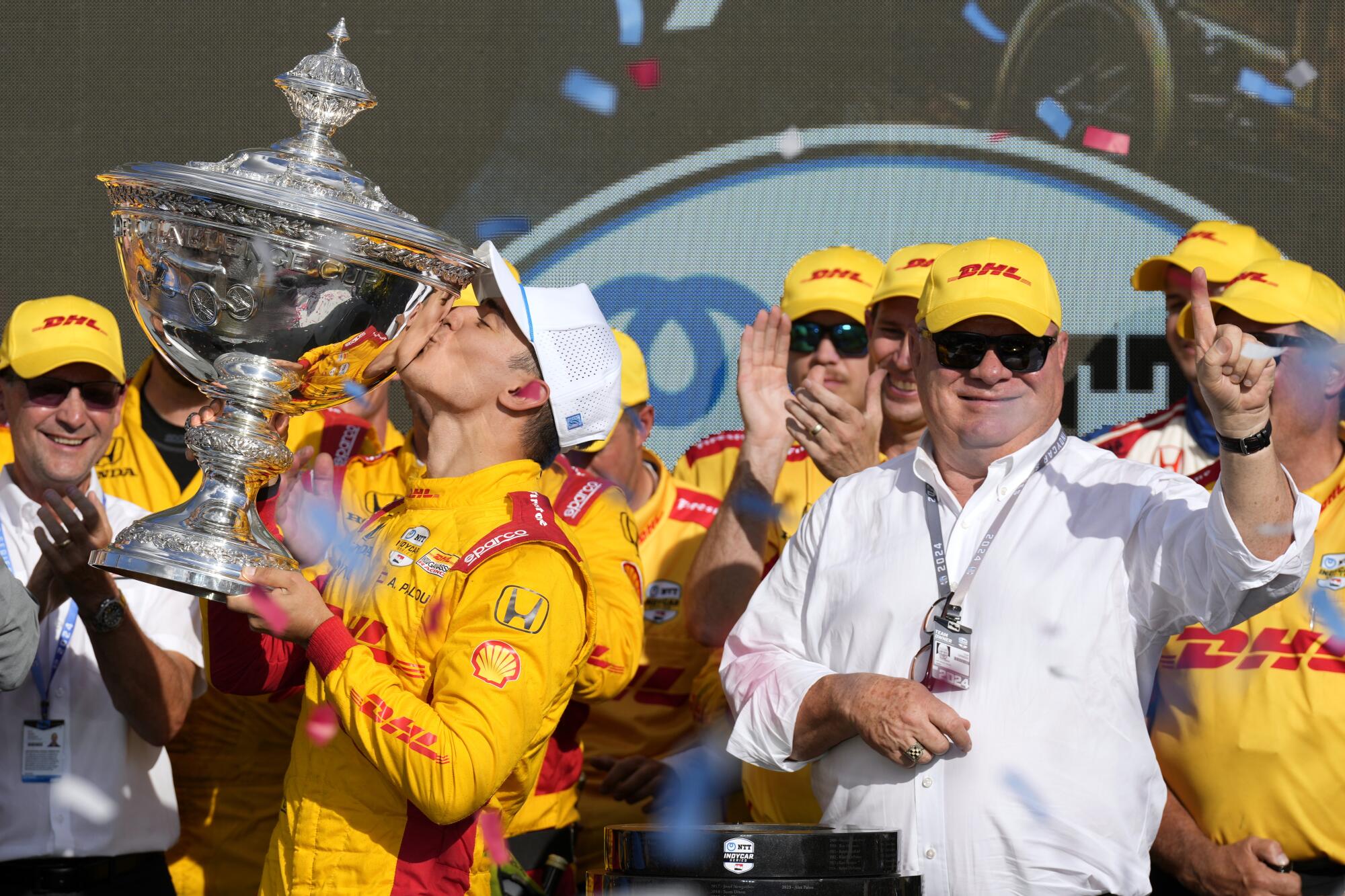 FILE - Alex Palou, front left, kisses his trophy as he celebrates with te