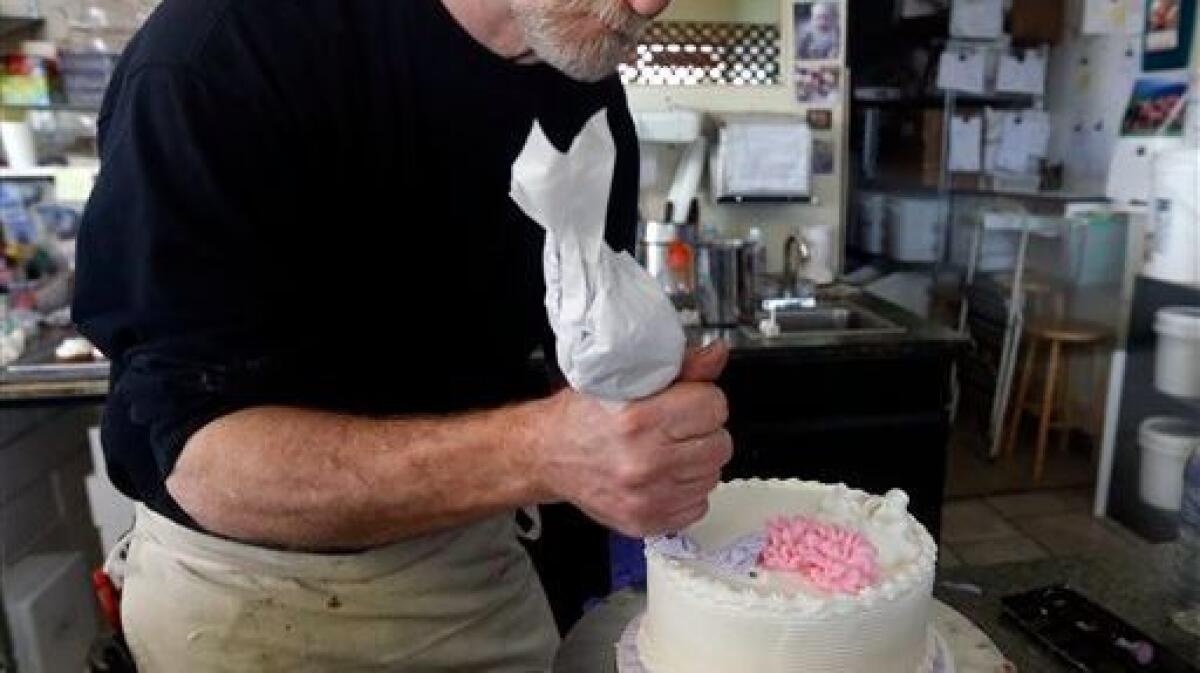 Masterpiece Cakeshop owner Jack Phillips decorates a cake inside his store, in Lakewood, Colo. on March 10, 2014.