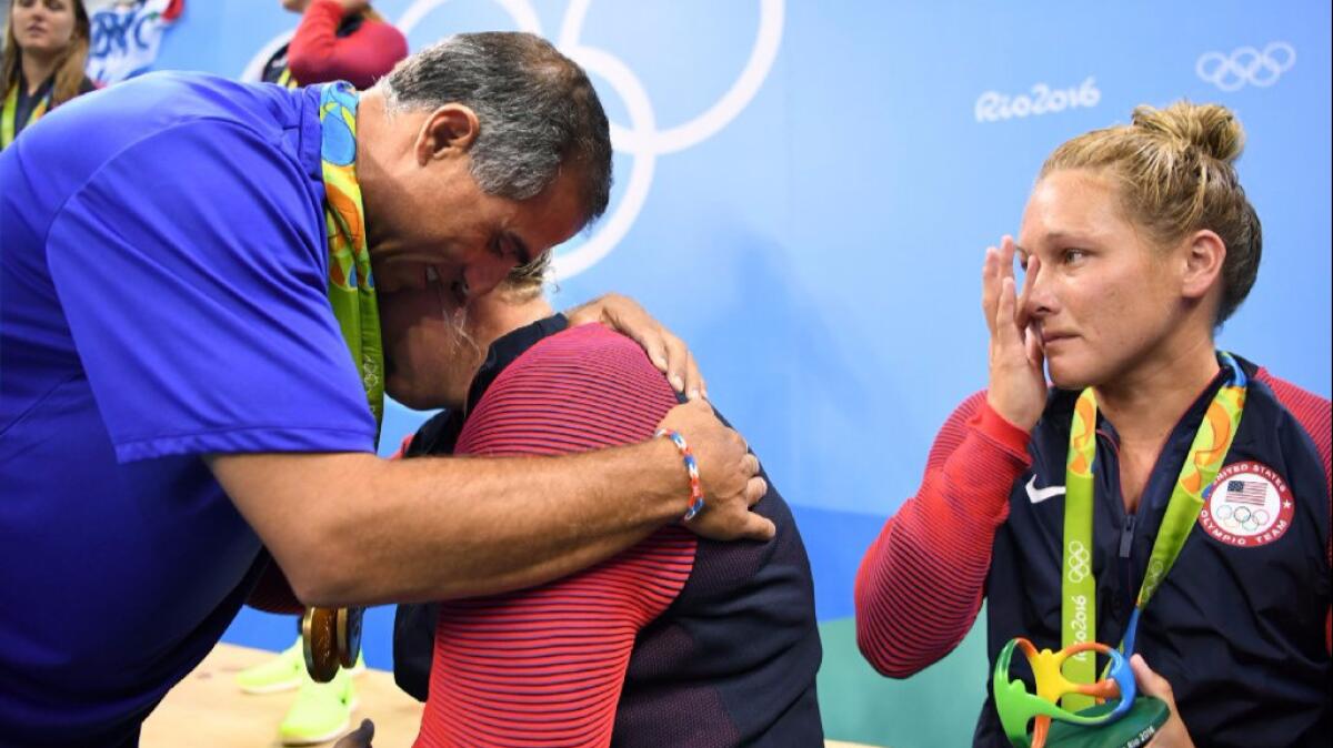 U.S. women's water polo Coach Adam Krikorian and team member Melissa Seidemann embrace after the U.S. won the gold-medal game against Italy. Krikorian's brother died recently, and Seidemann's mother is ill.