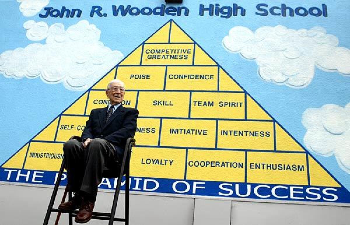 John Wooden holds court at a ceremony to rename Aliso High School in Reseda as John R. Wooden High School. Wooden is sitting in front of a mural that outlines his Pyramid of Success motivational program. See full story