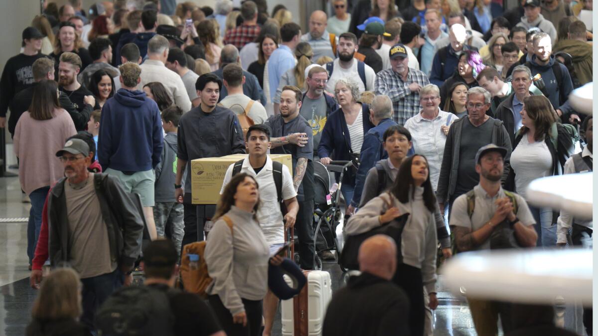 Travelers walk through Salt Lake City International Airport 