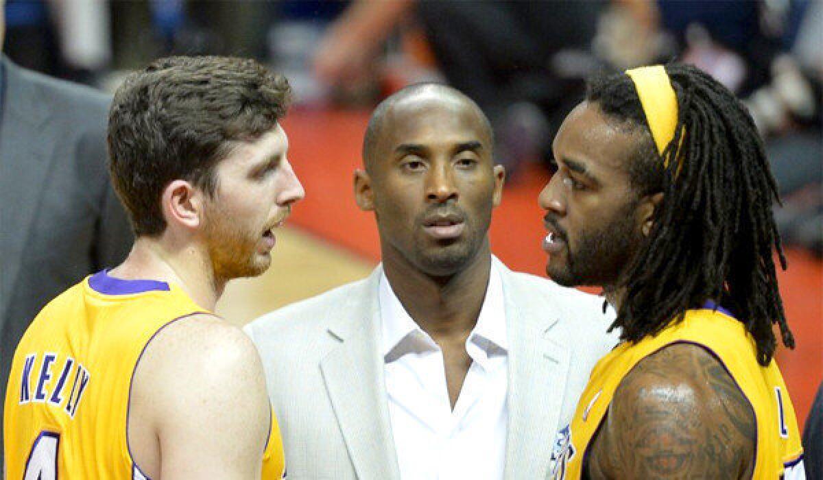 Lakers rookie Ryan Kelly, left, and Jordan Hill, right, are joined by Kobe Bryant during an exhibition game in October.