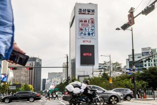 In this photo taken on October 7, 2021, a large digital screen on a building displays the logo of Netflix, producers of the South Korean hit series "Squid Game", as commuters drive on a road in Seoul. - A dystopian vision of a polarised society, Netflix smash hit Squid Game blends a tight plot, social allegory and uncompromising violence to create the latest South Korean cultural phenomenon to go global. - TO GO WITH AFP STORY SKOREA-US-TELEVISION-SOCIAL-SQUID GAME,FOCUS BY CLAIRE LEE (Photo by Anthony WALLACE / AFP) / TO GO WITH AFP STORY SKOREA-US-TELEVISION-SOCIAL-SQUID GAME,FOCUS BY CLAIRE LEE (Photo by ANTHONY WALLACE/AFP via Getty Images)