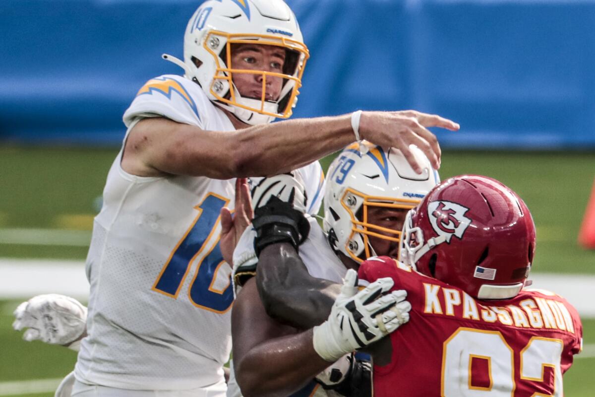 Chargers quarterback Justin Herbert passes under pressure.