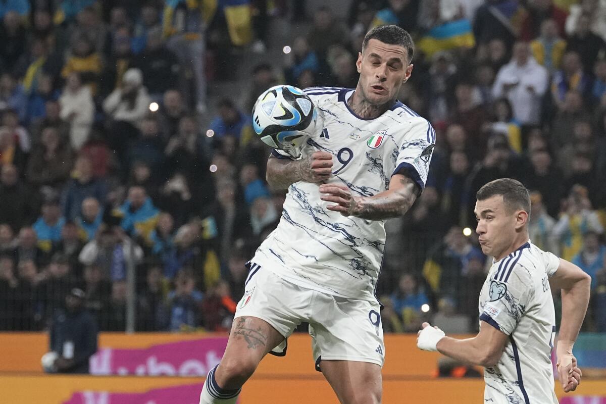 El italiano Gianluca Scamacca despeja un balón durante el partido contra Ucrania