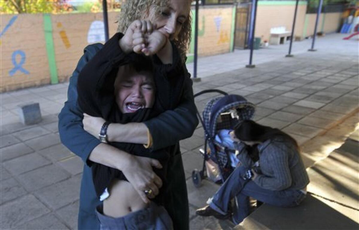 Teacher Jacqueline Gonzalez holds Matias Gonzalez, 3, during his first day of classes in Santiago, Monday, March 8, 2010. Hundred of schools are still closed after an 8.8-magnitude earthquake struck central Chile last Feb. 27, causing widespread damage. (AP Photo/Jorge Sanchez)