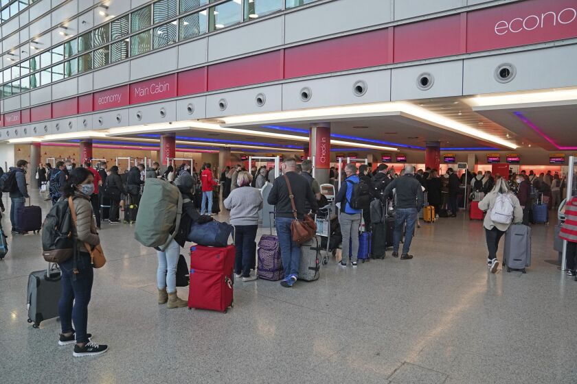 Passengers queue at London Heathrow Airport's T3 as the US reopens its borders to UK visitors in a significant boost to the travel sector, in London, Monday, Nov. 8, 2021. (Steve Parsons/PA via AP)