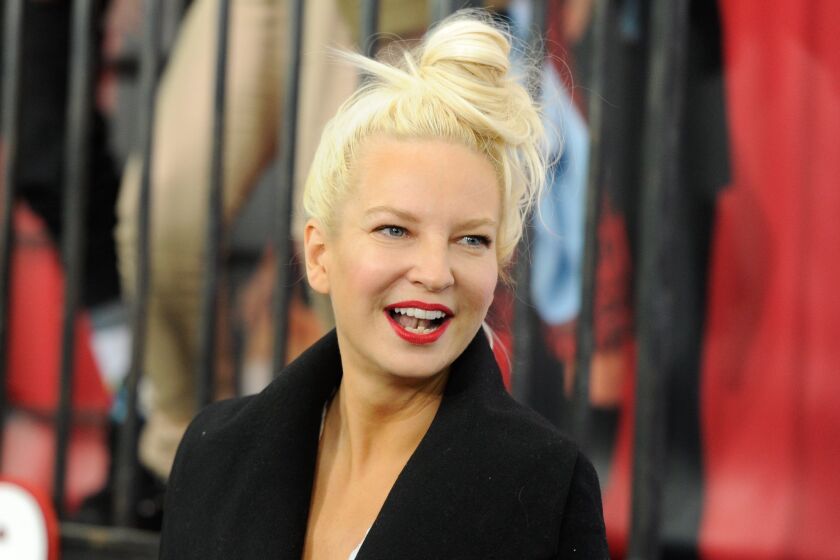 Sia wearing her hair in a loose bun and a black blazer