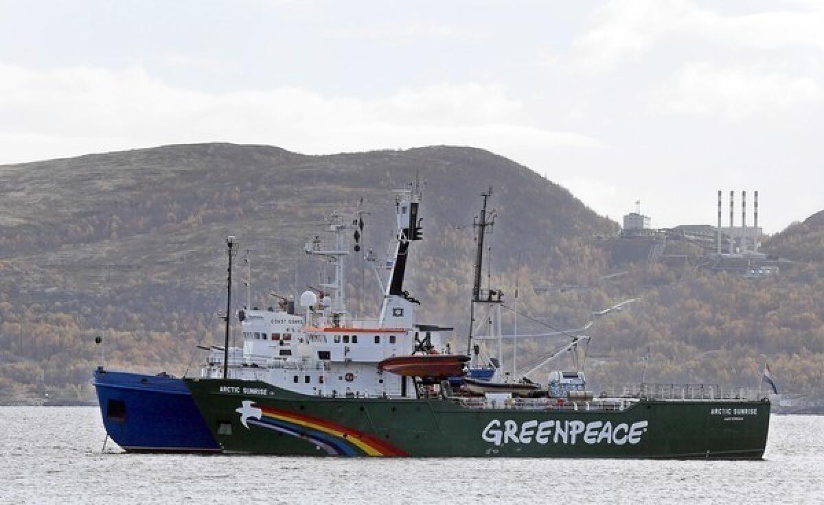 A Greenpeace vessel is escorted by a Russian coast guard boat in Kola Bay.