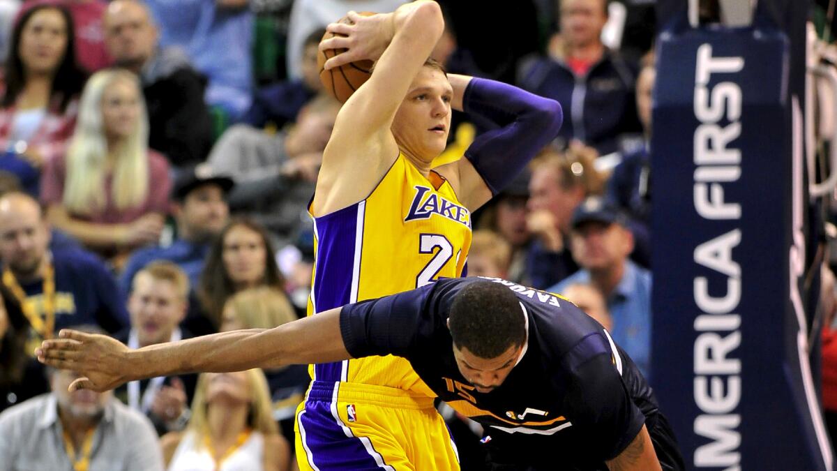 Lakers center Timofey Mozgov grabs a rebound against Jazz forward Derrick Favors during a game Oct. 28.