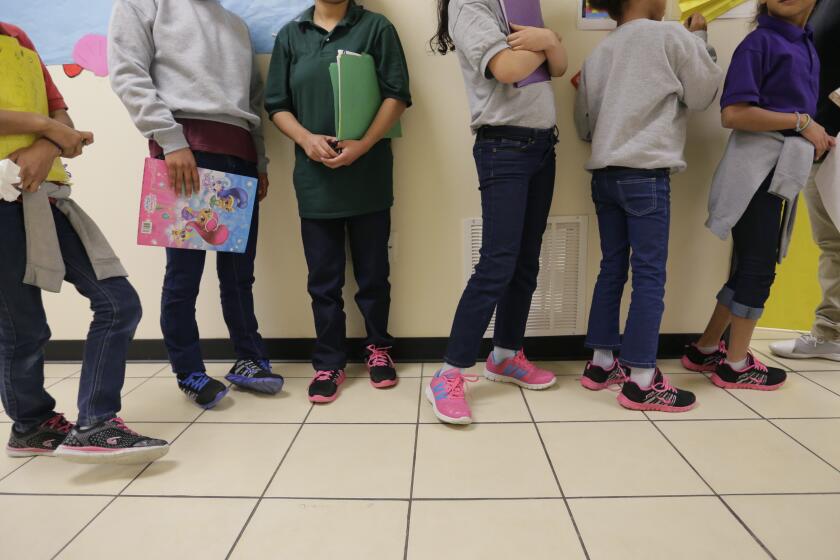 FILE - In this Aug. 29, 2019, file photo, migrant teens line up for a class at a "tender-age" facility for babies, children and teens, in Texas' Rio Grande Valley, in San Benito, Texas. With its long-term facilities for immigrant children nearly full, the Biden administration is working to expedite the release of children to their relatives in the U.S. The U.S. Health and Human Services on Wednesday, Feb. 24, 2021, authorized operators of long-term facilities to pay for some of the children's flights and transportation to the homes of their sponsors. (AP Photo/Eric Gay File)