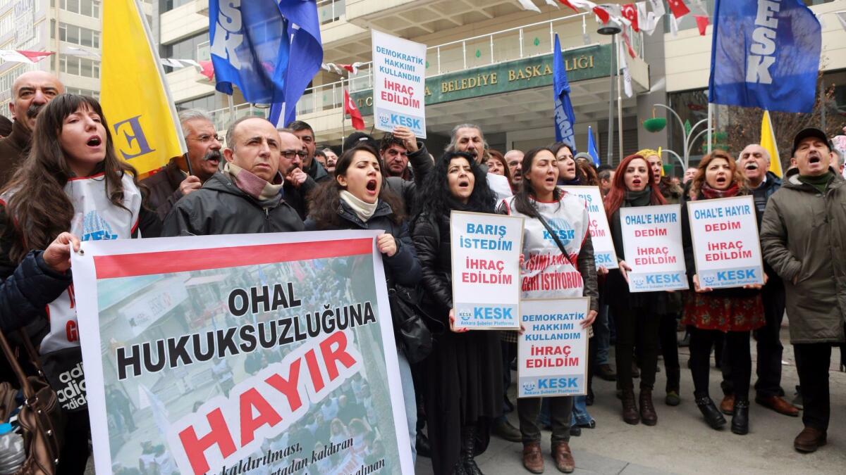 Demonstrators shout slogans and hold banners during a protest in Ankara, Turkey, against the dismissal of academics from universities.